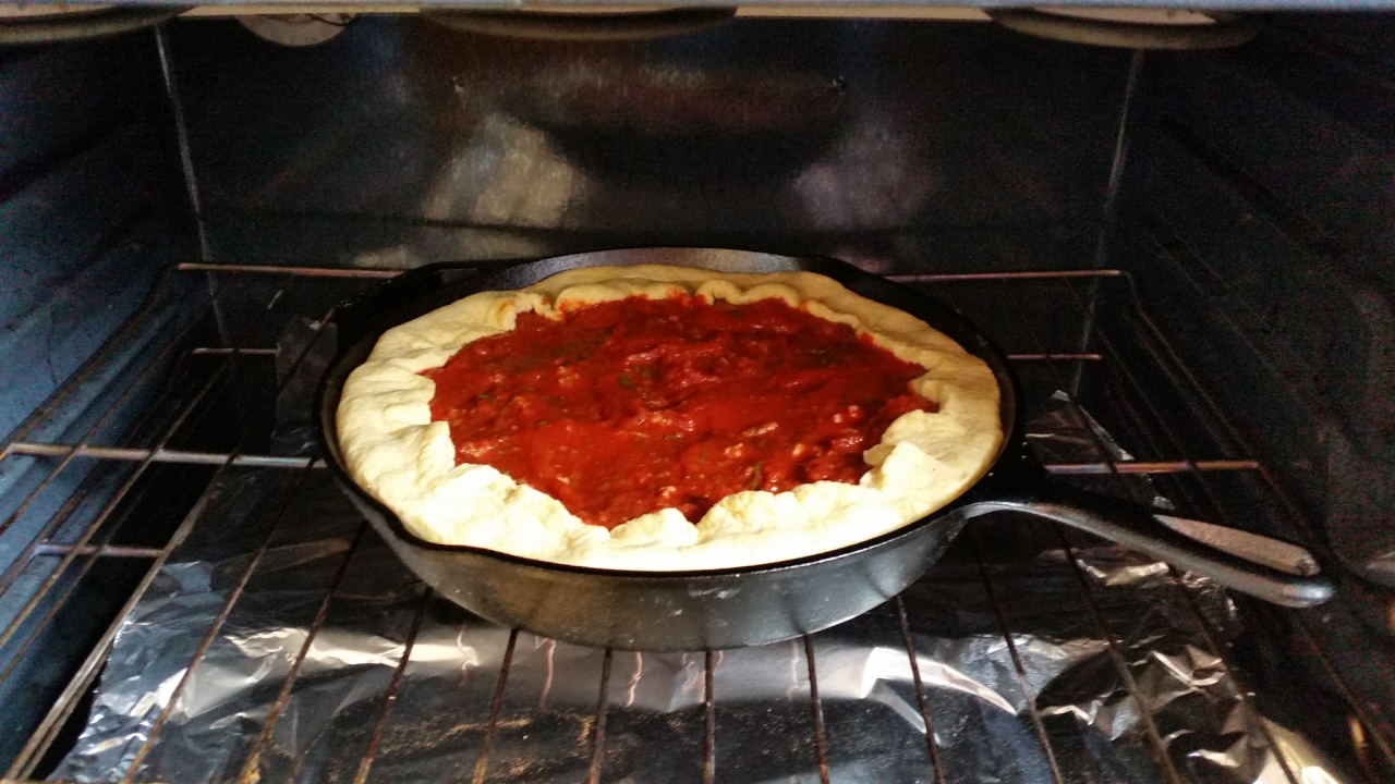 a deep dish pizza ready to be cooked in the oven